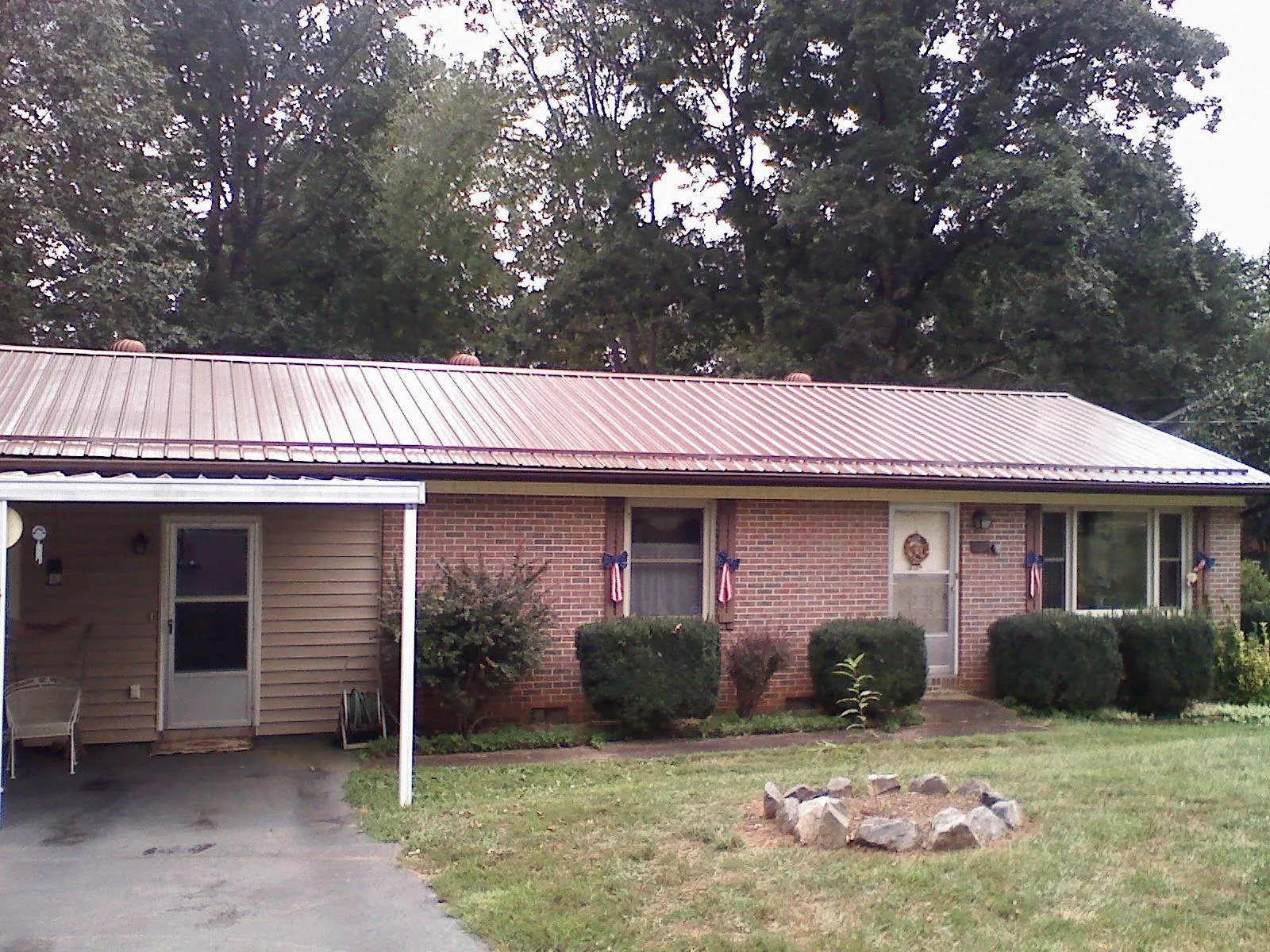 Bronze metal roof and carport on a brick ranch home — Roof Repair work by our crew in Worthington